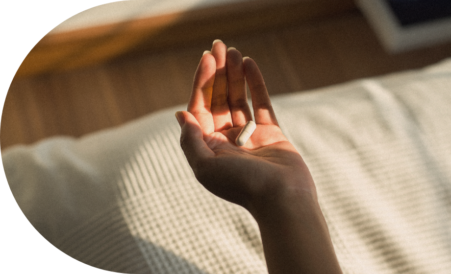 An open hand holding a capsule in warm sunlight